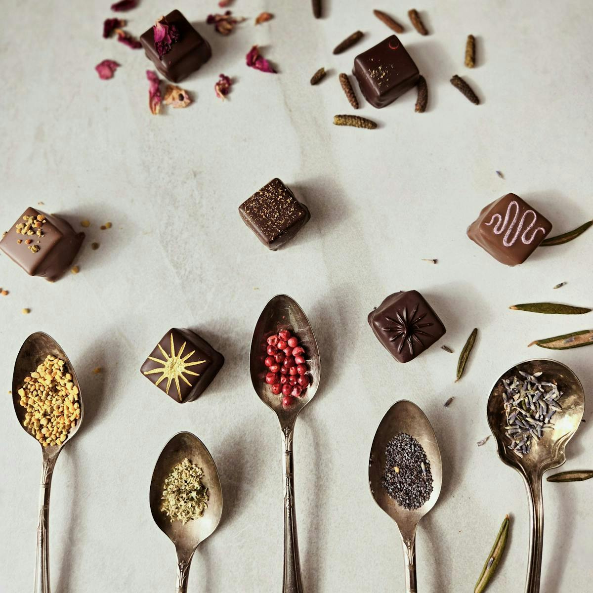 chocolates and spoonfuls of ingredients displayed on a table