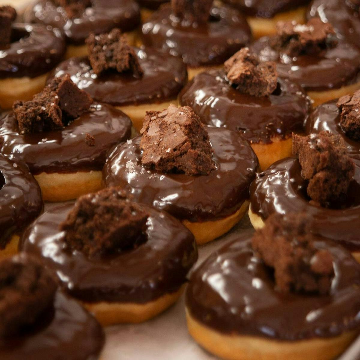 A table full of chocolate glazed doghnuts