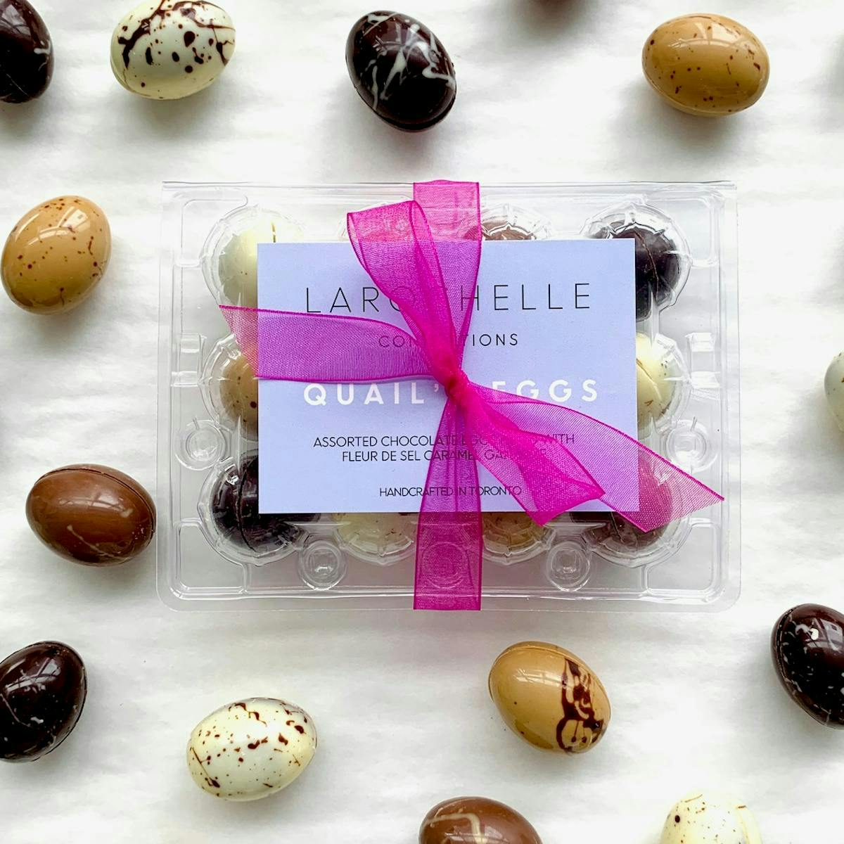 Chocolate quail eggs from La Rochelle in various colour with a box tied with a pink bow.