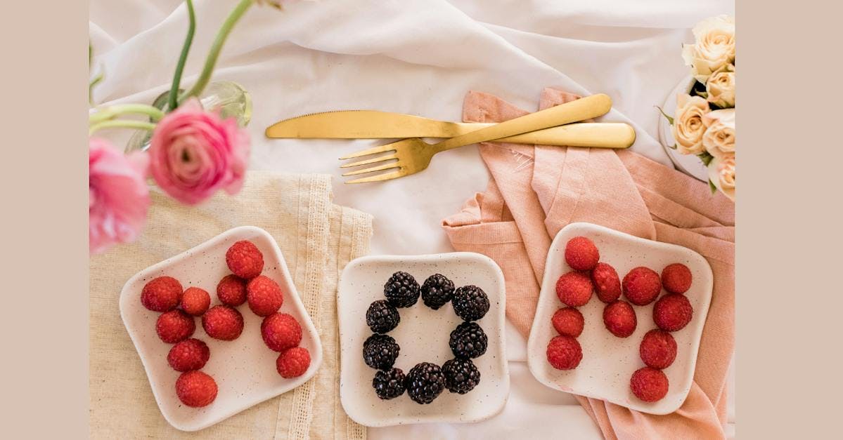 breakfast in bed for mom: flowers and berries on place spell out m-o-m